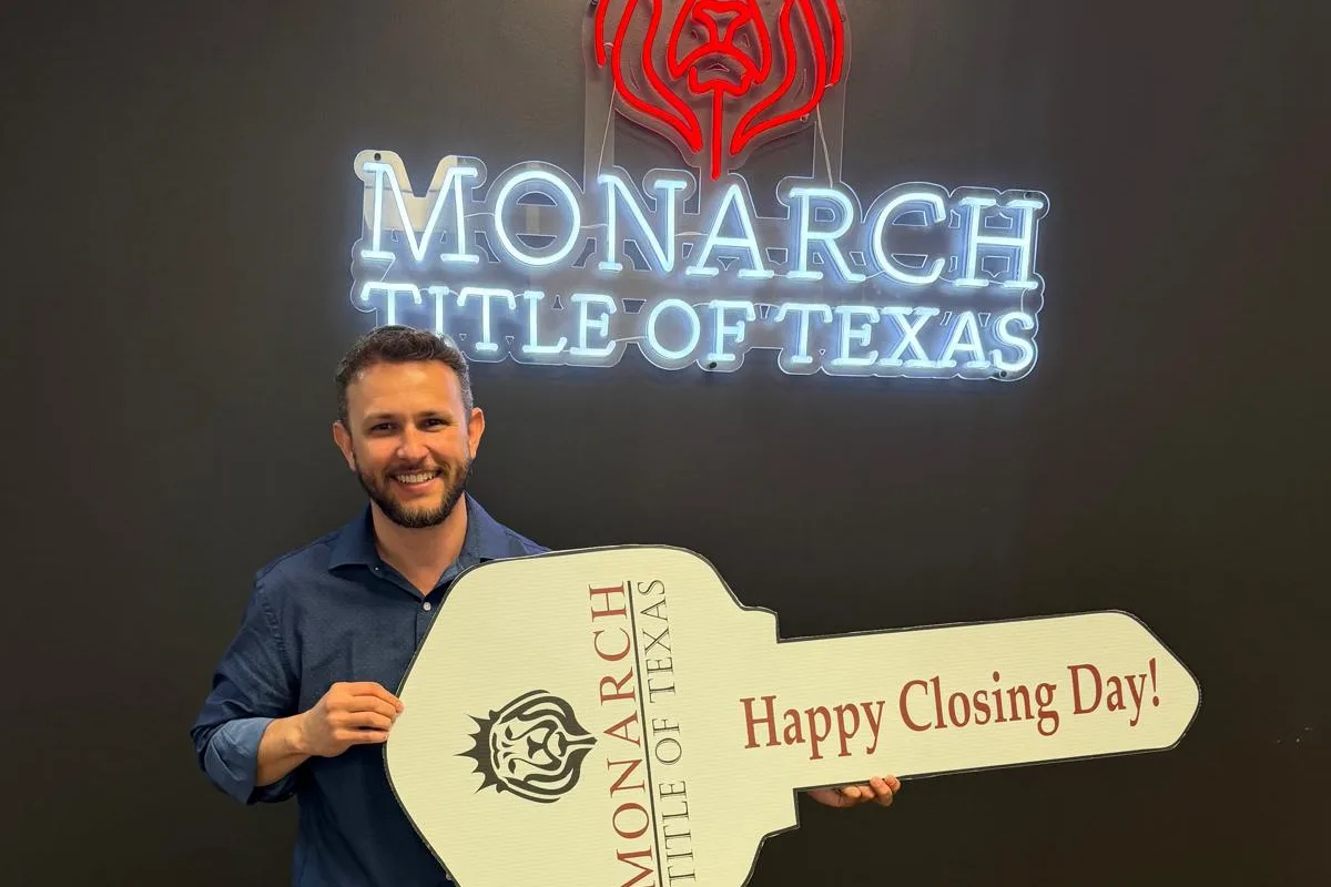 Client smiling with a giant Happy Closing Day key at the title office