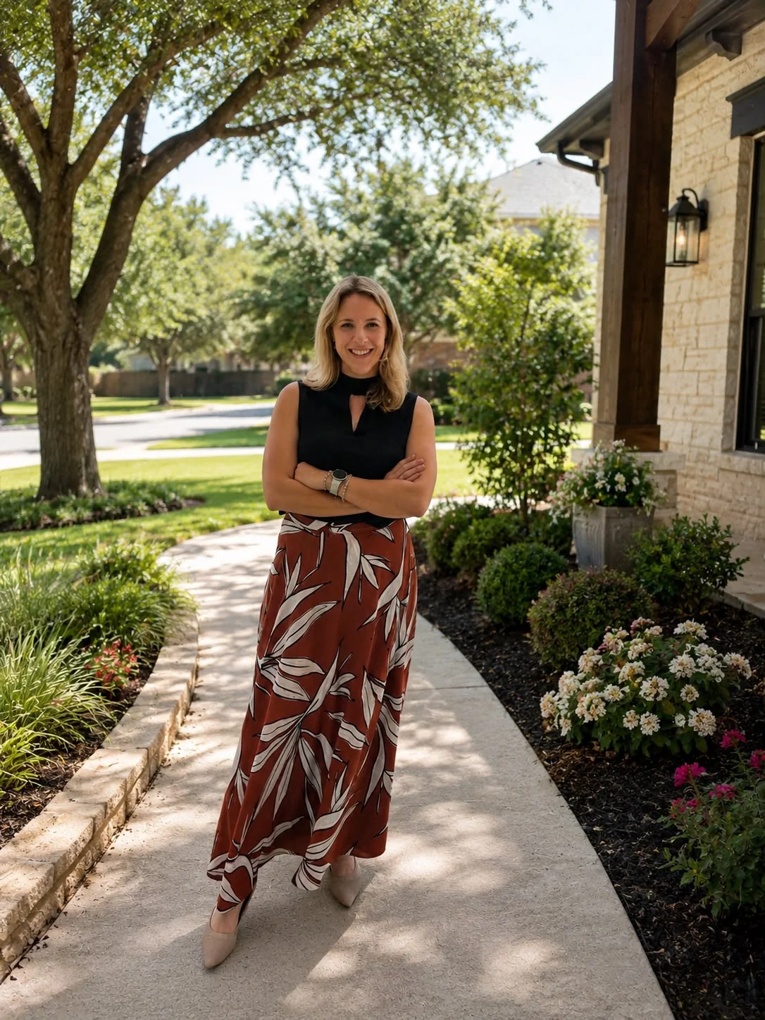 Carina Morris standing in front of a stone home on a sunny day