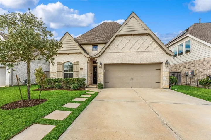 Cream stone home with steep gables on Old Saddle Ln