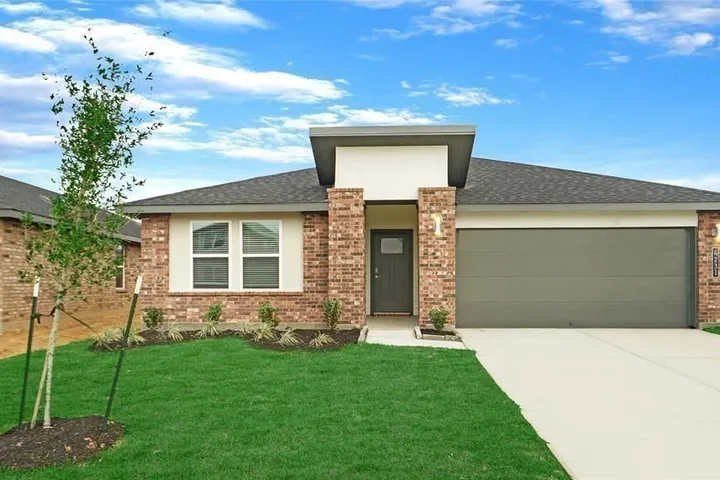 Newly built single-story home with a brick and stucco front on Pierce Place Ln